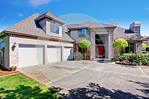 Large modern house with three garage spaces and concrete driveway.