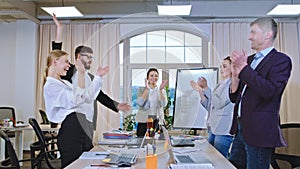 In a large modern office multiethnic office worker at the of the seminar they joining hands together and feeling a good