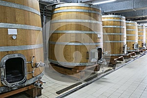 Large modern wine barrels at the winery, the concept of a large factory, production. Silver colored barrels, silver pipes on the