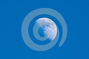 A large moon is in the sky above a blue sky