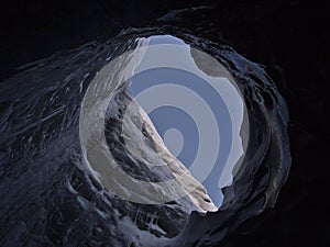 Large moulin hole in the ceiling of Sapphire Ice Cave, located in BreiÃ°amerkurjÃ¶kull glacier, VatnajÃ¶kull, Iceland.