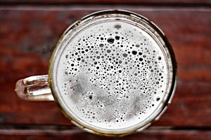 Large mug of beer with foam and bubbles top view