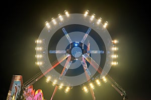 A large night funfair ride carousel with colorful lights