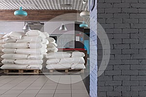 A large number of bags of flour stand in an empty cafe, which has no customers