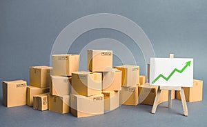 A large number of cardboard boxes and sign with green up arrow. rate growth of production of goods and products, increasing