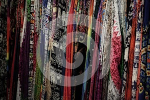A large number of colorful shawls, patterned textiles, background