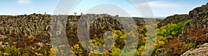 A large number of stone minerals covered with green vegetation lying above a small river in picturesque Ukraine and its