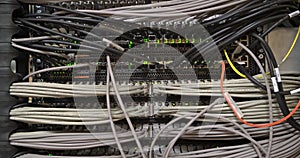 Large number of wires and cables in modern server and network equipment with flashing green lights and optical severs computer in