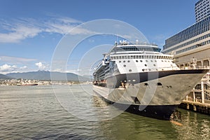 large ocean cruise liner is moored at the pier in a modern seaside town