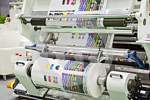 Large offset printing press or magazine running a long roll off paper in production line of industrial printer machine