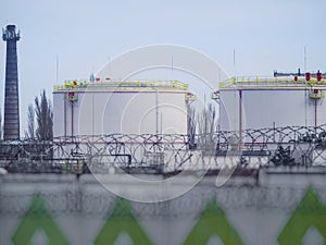 Large oil tanks in a fenced area