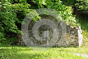 Large old 19th Century stone root cellar with arched top seen