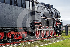 Large old black and red steam locomotive, wheels of old steam locomotives. a pair of wheels. retro locomotives. vintage
