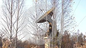 A large old radar at an old base in the middle of the forest