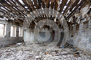 Large old ruined room with garbage and empty windows