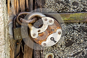 A large old rusty metal padlock, object detail, closeup, big steel lock up close, keyhole, locked door, safety security symbol,