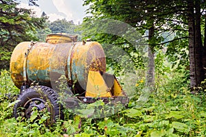 Large old yellow watering and milk barrel water tank