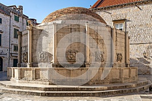 Large Onofrio's Fountain with carved masks in old town Dubrovnik street stradun in Croatia summer morning