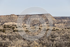 Large open grassy field with mountain range in back on clear day