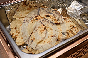 A large open tray of Indian Naan leavened oven baked flatbread