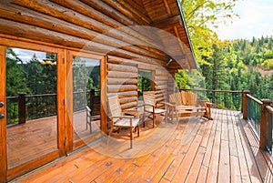 A large open wooden deck on a rustic log cabin home in the mountains of the American Northwest