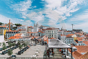 A large orange building with a mountain in the background. View of the rooftops of Lisbon. Portugal