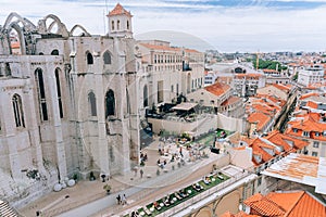 A large orange building with a mountain in the background. View of the rooftops of Lisbon. Portugal