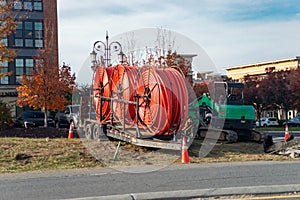 Large orange cable reels on trailer at roadside construction site