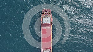 Large orange dock bulk carrier ship general cargo in the open ocean.
