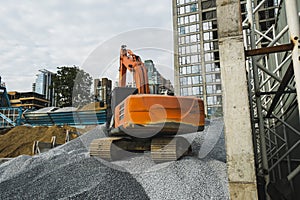 Large orange excavator working on a gravel on construction site. Details of industrial excavator. Big excavator standing