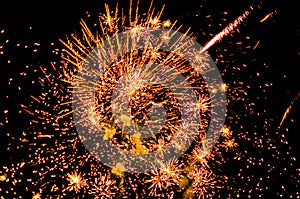 Large orange firework with fiery trails in the sky