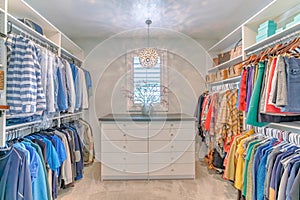 Large organized walk in closet with ball pendant lighting fixture