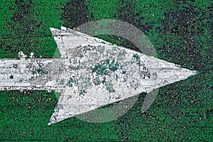 Large painted grungy arrow on weathered green background