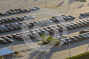 Large parking lot of local dealer with many brand new cars parked for sale. Development of american automotive industry