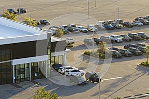 Large parking lot of local dealer with many brand new cars parked for sale. Development of american automotive industry