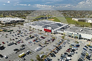 Large parking lot with many parked cars. Big carpark at supercenter shopping mall with lines and markings for vehicle