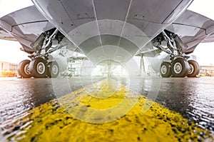 Large passenger aircraft parked at the airport, bottom view wing and landing gear.