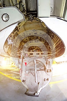 Large passenger airplane maintenance personnel working on aircraft main landing gear repair detail exterior close up view.