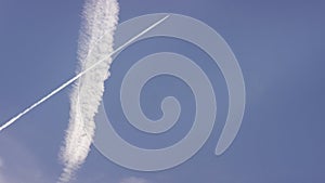 Large passenger supersonic plane flying high in clear blue sky, leaving long white trail. Airplane flying in white