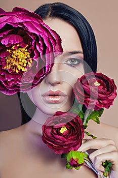 Large peonies near a woman face, art fashion flowers in front of a girl, nature face care, natural cosmetics