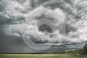 Large picturesque rain clouds over fields and meadows of Russia