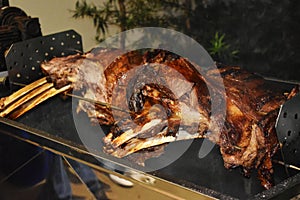 Large piece of beef rib roasted on the roller. Meat barbecue for many people. Roasted beef. Steak on the bone