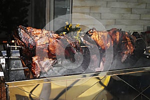 Large piece of beef rib roasted on the roller. Meat barbecue for many people. Roasted beef. Steak on the bone