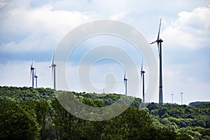large piece of forest and in the middle of it a large wind farm with many wind turbines