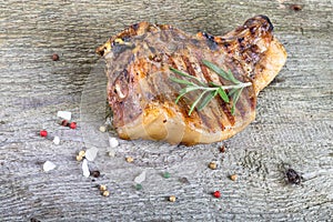 Large piece of fresh pork meat on a bone prepared on a grill pan on old wooden table for background