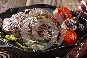 Large piece of grilled meat with vegetables in a cast iron pan, close-up, eating out,