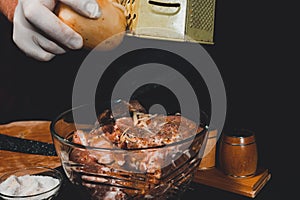 A large piece of pork is cut into pieces, marinated by the chef with spices, and the chef rubs the potatoes on a grater to the