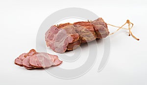 A large piece of pork deli meat with slices on a white background