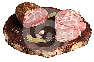 Large piece of pork ham and sliced ham on a kraft wooden board. Delicious baked meat with spices in close-up. Top view. Large