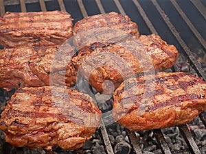 Large pieces of meat are roasted on metal bars